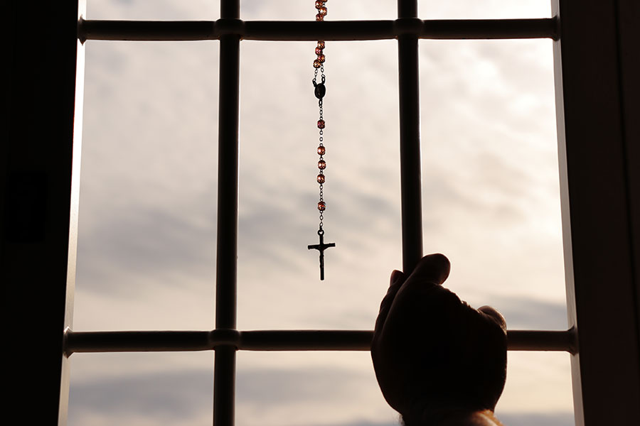 Rosary hangs on a grated window